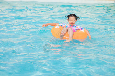 夏日游泳圈女孩小女孩坐在游泳圈上在泳池游泳背景