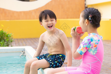 游泳开始小男孩和小女孩开始的坐在泳池边吃西瓜背景