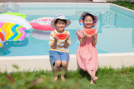 小男孩和小女孩坐在泳池边吃西瓜图片