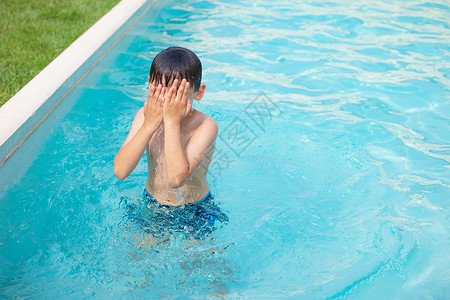 小男孩泳池中戏水图片