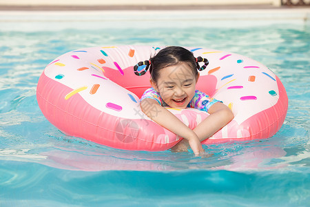 夏日游泳圈女孩小女孩趴在游泳圈上开心戏水背景