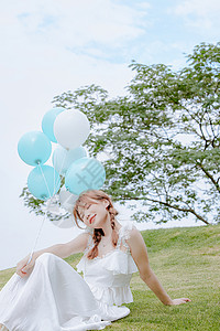 夏日气球美女手拿气球坐在草地上的夏日清新美女背景
