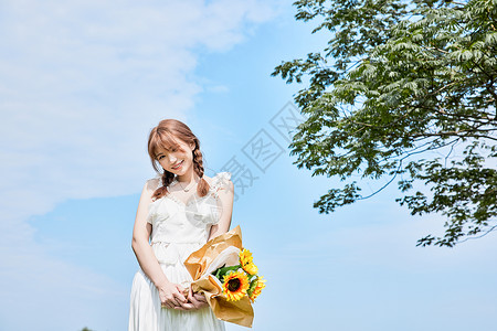 摘夏日葵夏日美女手拿夏日葵背景