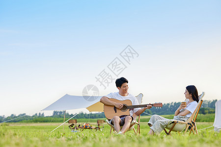 青年男女户外露营弹吉他图片