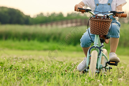 小孩自行车小男孩户外草坪上骑车特写背景