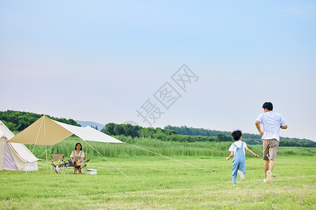 公园帐篷小男孩和爸爸在草坪上追逐打闹背影背景