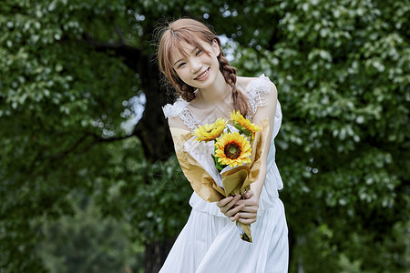 绿色年轻大学生手捧向日葵的清新夏日美女背景