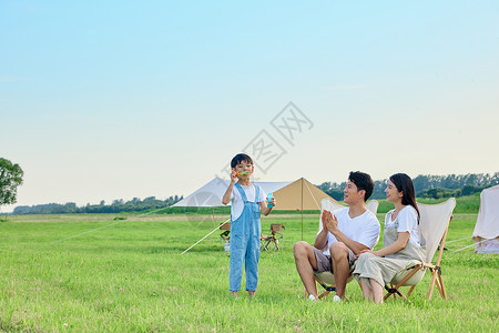 假期公园放风筝一家人夏日户外露营背景