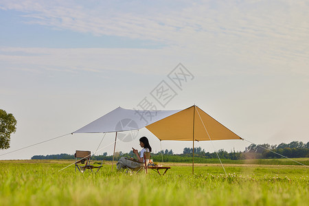 暑假休息年轻美女户外露营休息玩手机背景