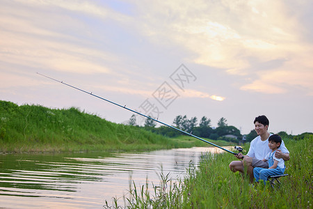 周末钓鱼年轻爸爸带着儿子户外钓鱼背景