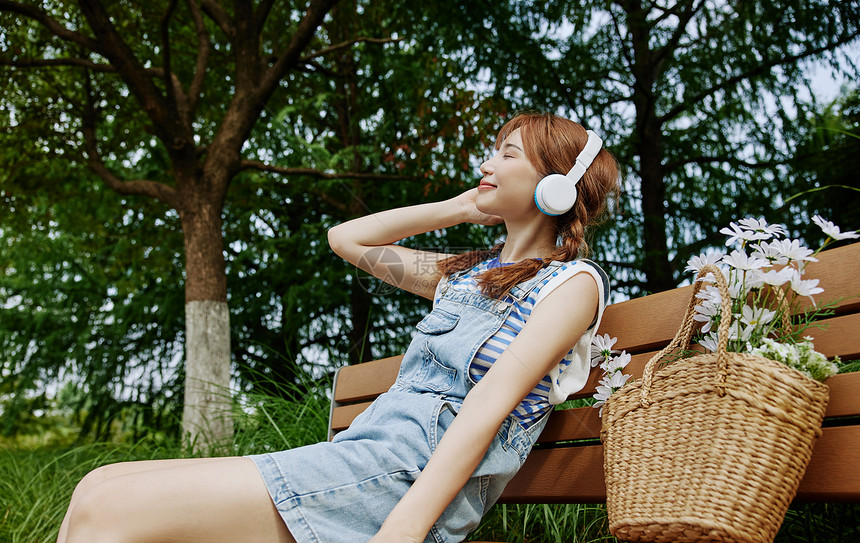 戴着耳机听音乐的夏日美女图片