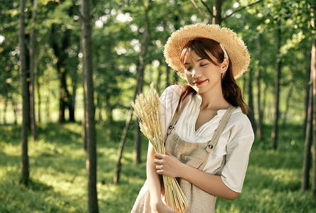 夕阳下手拿麦穗的夏日清新美女高清图片