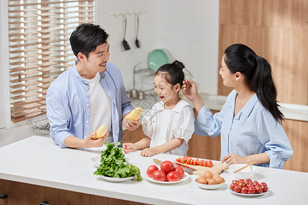 温馨一家三口在厨房做饭高清图片