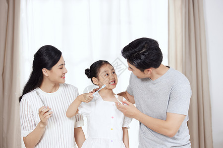 小孩刷牙父母帮女儿检查牙齿背景