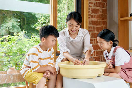 端水盆男孩陶艺老师指导小朋友做陶罐背景