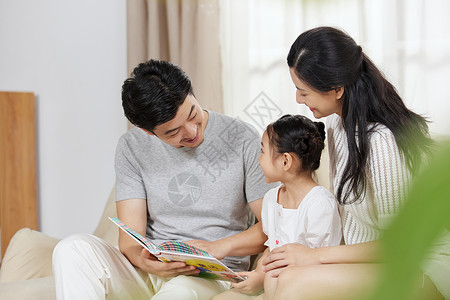 在家读书的女孩父母在家给女儿念书背景