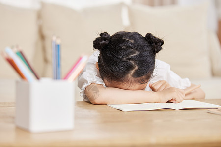 儿童课本小女孩在家做作业疲惫睡着背景