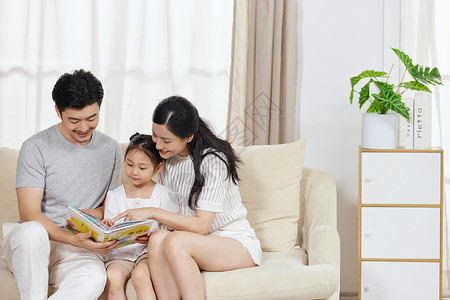 和孩子一起读书一家三口一起在沙发上看书背景