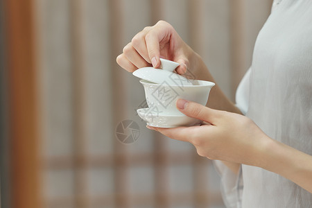 女性端着茶杯手部特写背景图片