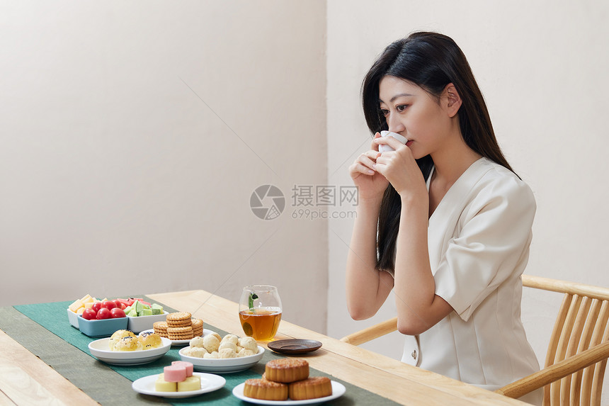 年轻美女中秋节品茶吃月饼图片