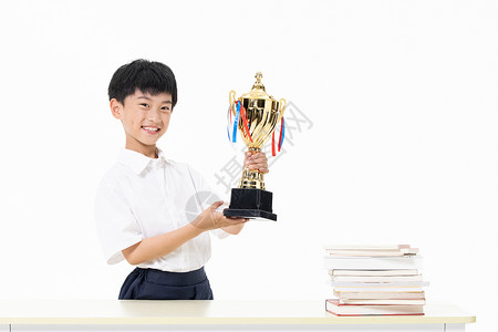 双手捧着奖杯开心的小男孩背景图片