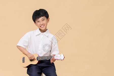 乐器吉他小孩学习尤克里里的小男孩背景