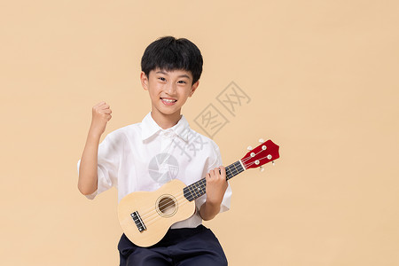 乐器吉他小孩小男孩手拿尤克里里做加油手势背景
