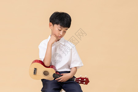 乐器吉他小孩学习尤克里里的小男孩背景