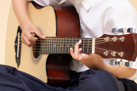 演奏小男孩弹吉他的手部特写背景