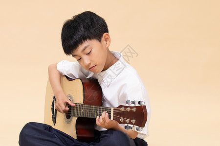 暑假招生暑期班弹吉他的小男孩背景