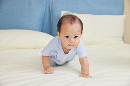 宝宝婴幼儿居家在床上爬背景图片