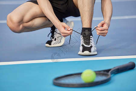 网球手蹲下系鞋带图片