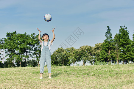 小男孩户外游玩扔足球图片
