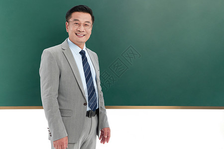 中年国学老师在黑板前喝水中年教授在黑板前面带微笑背景