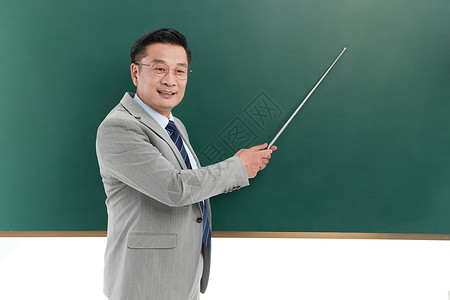 中年教授手持教棒在黑板前讲课图片