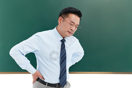 教学压力中年教授在黑板前双手撑腰面露疲惫背景