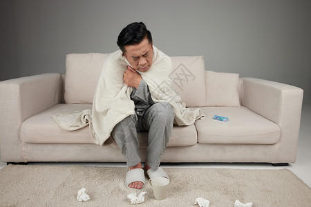 药盒设计中年男子患感冒坐在沙发上用毯子保暖背景