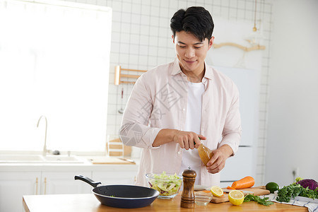 砧板菜刀帅气的年轻男士在厨房做沙拉背景