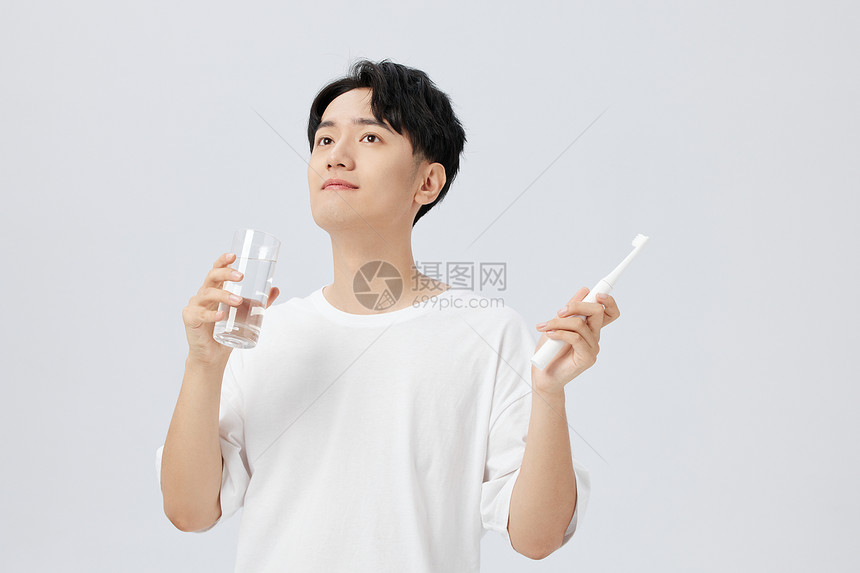 日系男生手拿水杯刷牙图片
