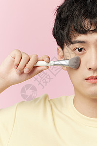 日系化妆韩系帅哥使用美妆刷特写背景