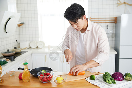 早晨室内年轻的男人在厨房做饭背景