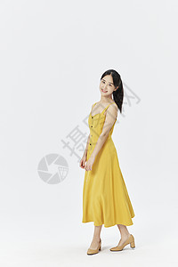 穿着黄色连衣裙的美女背景图片