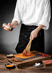 厨师正在给肉串撒辣椒粉背景图片