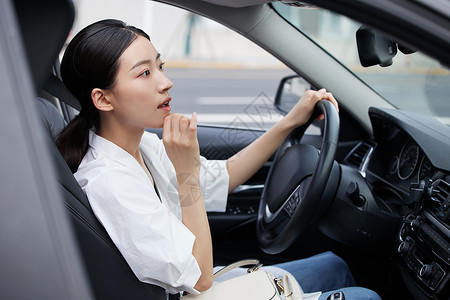 年轻女白领车内照镜子背景图片