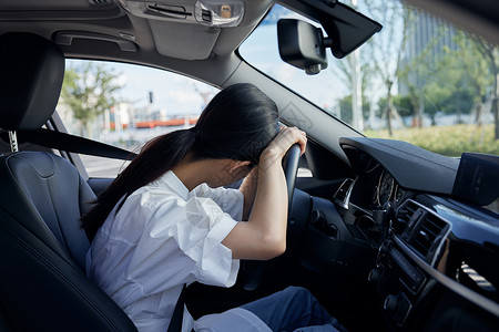 女性司机头靠方向盘休息图片