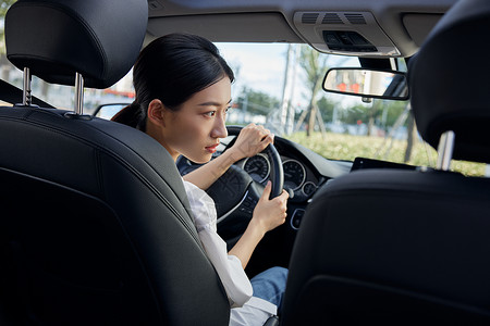 年轻女性白领驾车看右视镜背景图片