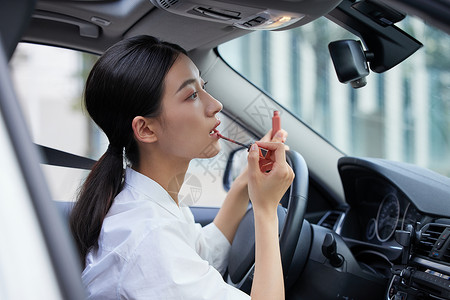 轿车标志年轻白领女性车内涂口红背景