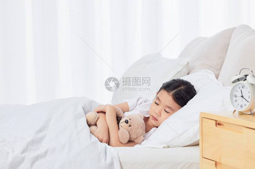 可爱儿童小女孩居家抱着玩偶熊睡觉图片