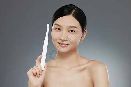肤护品女性使用电动牙刷背景