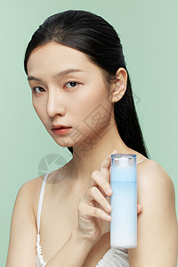 补水保湿养颜女性手拿乳液瓶特写展示背景